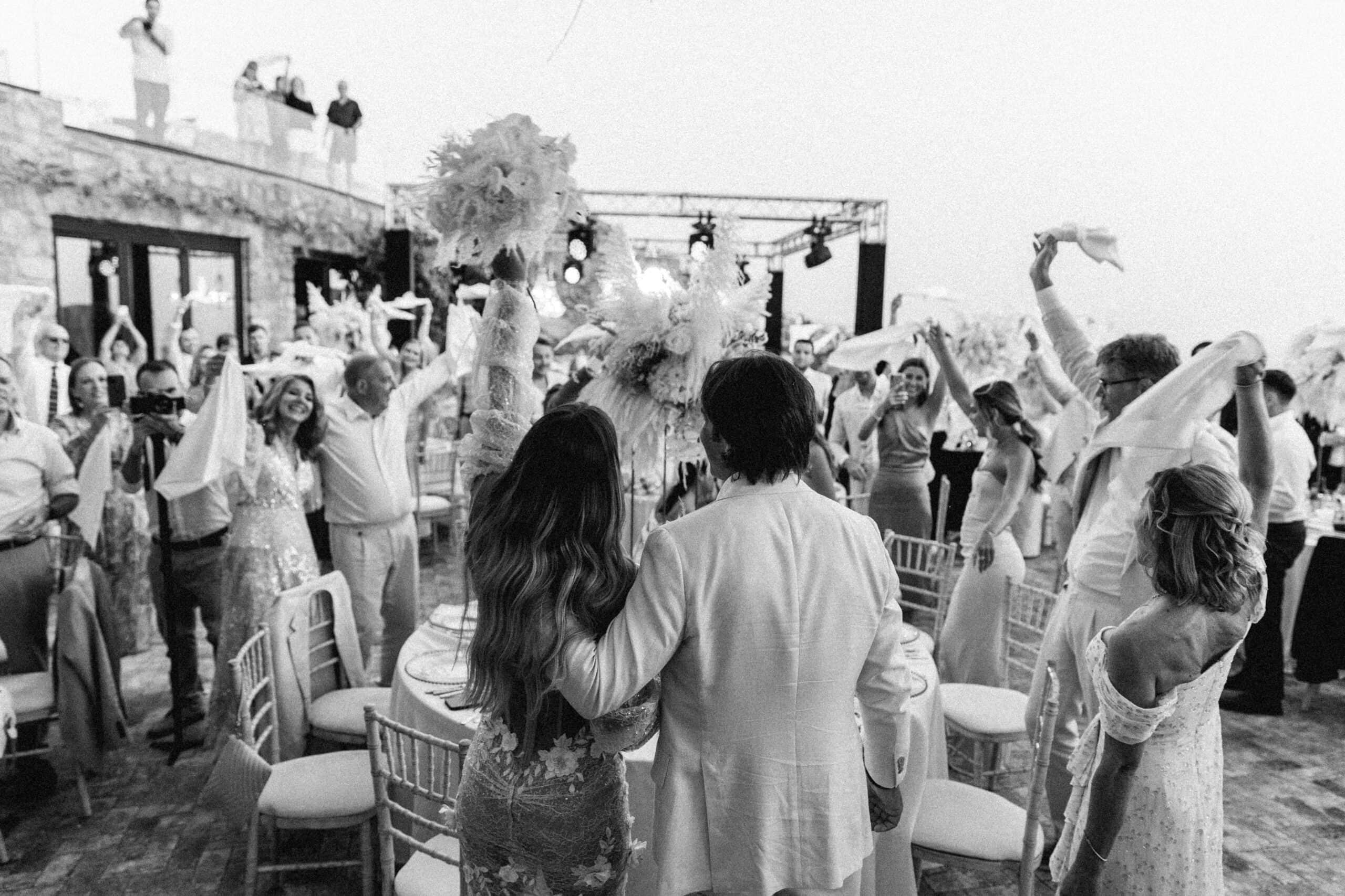 Black-and-white photo of guests celebrating at Liz and Josh's Mykonos wedding after-party