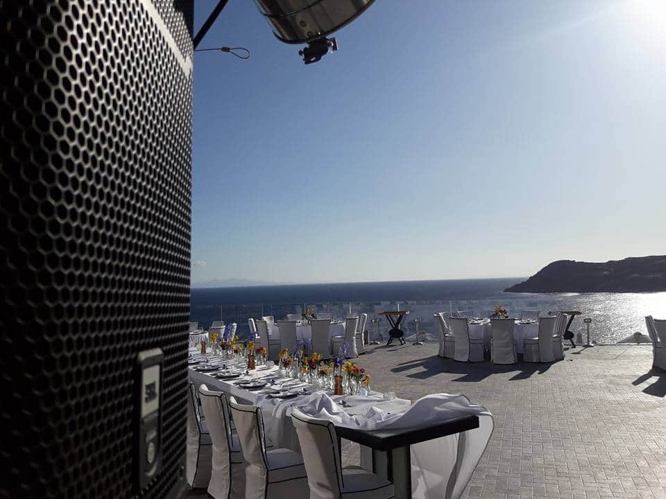 JBL speaker rigged beside a seaside wedding dinner terrace before the guests arrive